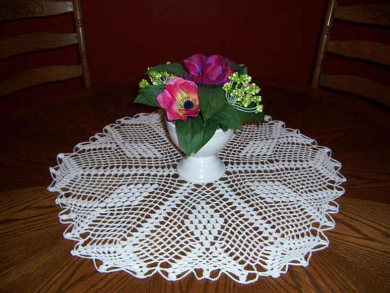 7. Uma forma bem comum de usar o centro de mesa de crochê é como base para um vaso de flores