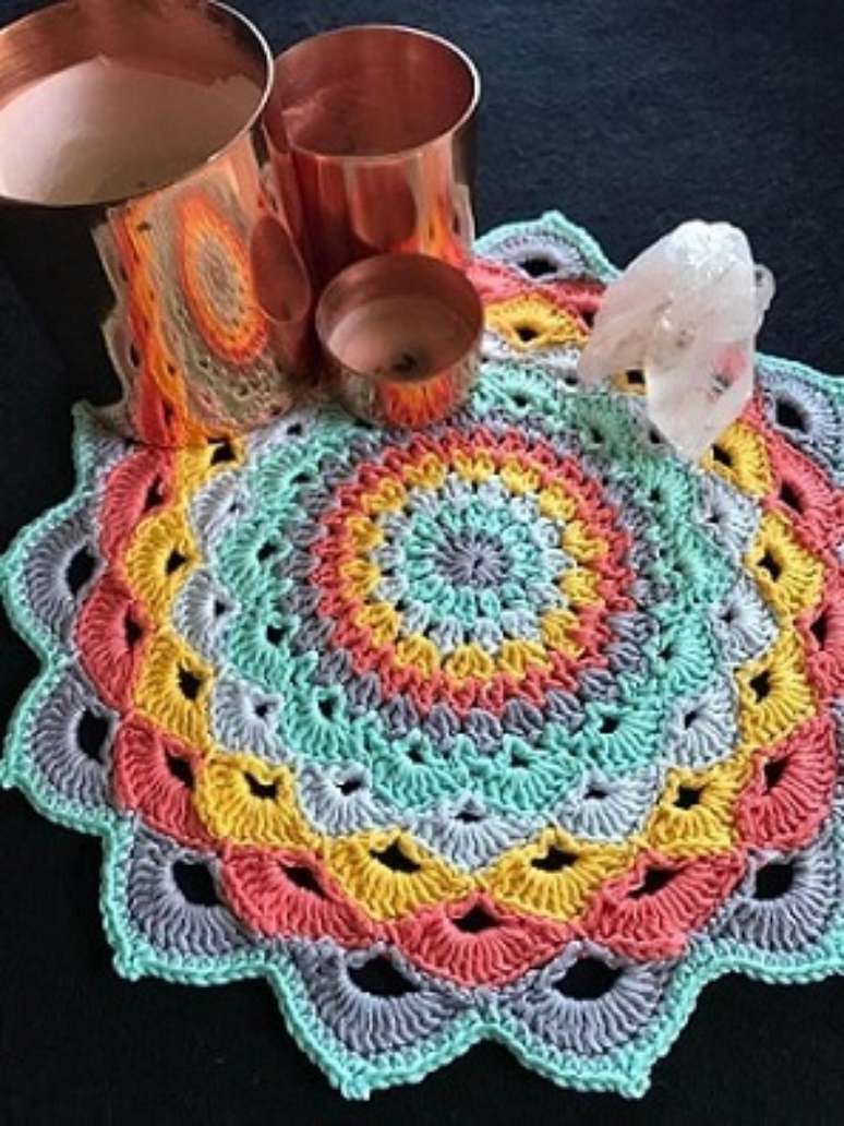 4. Aqui, o centro de mesa de crochê colorido é combinado com velas e cristais
