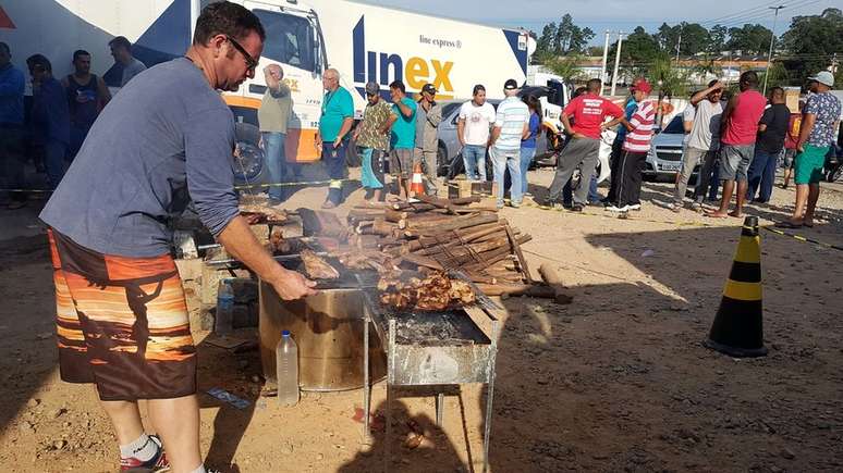 Voluntários passam parte do dia fazendo churrasco para caminhoneiros parados à beira da rodovia Régis Bittencourt