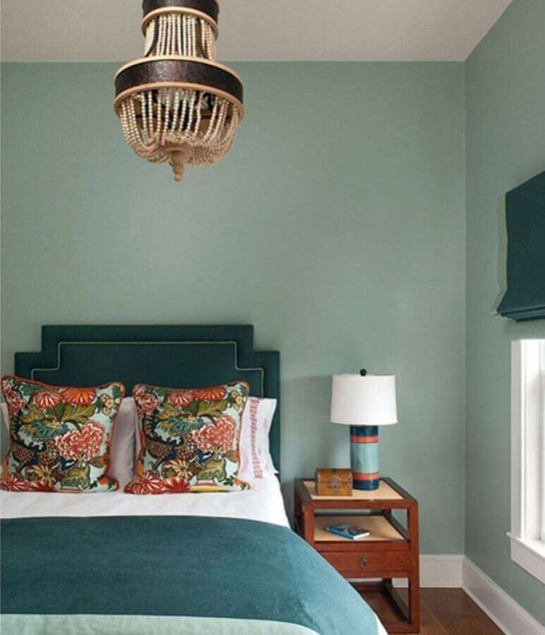 29. Quarto decorado com tons de verde e com lustre para quarto