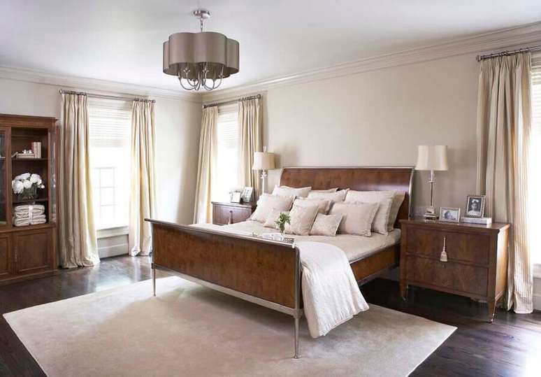 33. Quarto de casal todo decorado com m&oacute;veis de madeira e com lustre de metal