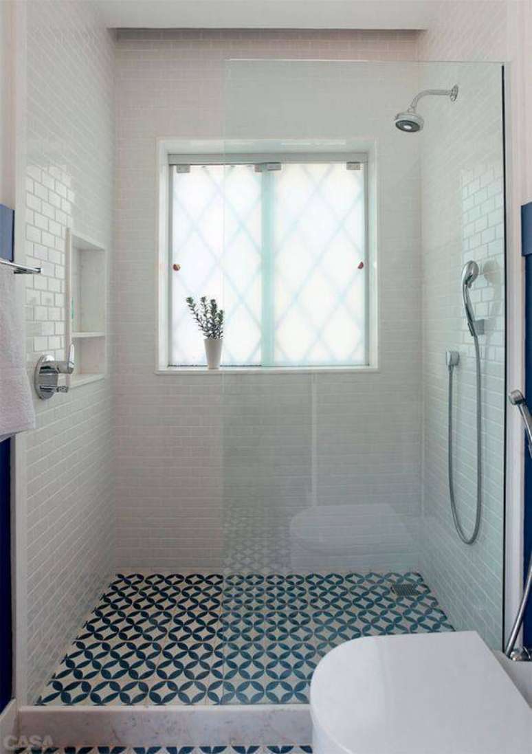 15. O piso cerâmico azul desenhado quebra a monotonia do ambiente branco, deixando o banheiro diferente