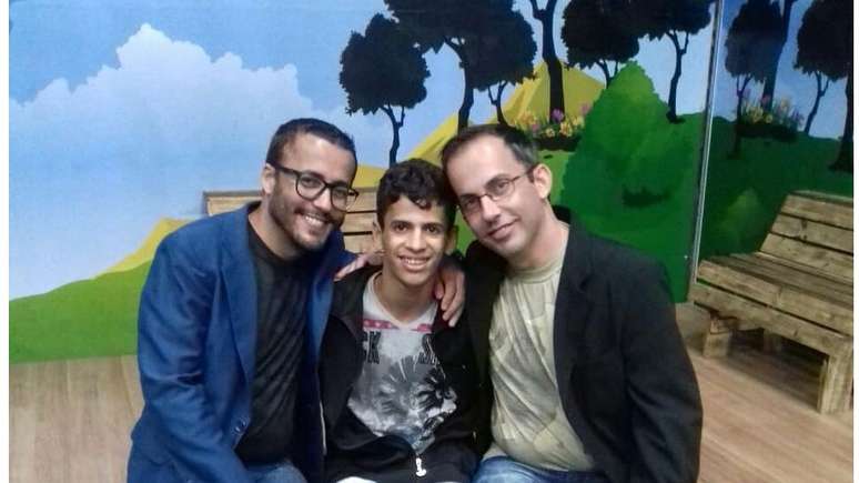 Leandro (&agrave; esquerda) e Edmundo Negri, com Jos&eacute;: Menino de 14 anos est&aacute; sendo adotado pelo casal ap&oacute;s sua foto ter sido postada no Facebook