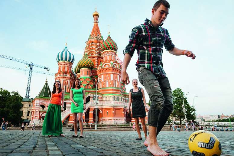 Universitário moscovita exibe truques com a bola para meninas durante passeio de domingo em frente à Catedral São Basílio, na Praça Vermelha de Moscou
