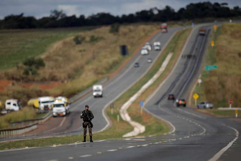 Army officers escort trucks transporting cooking gas and aviation gasoline to fuel airplanes at International Brasilia Airport, on the BR-040 highway in Luziania, May 30, 2018, 2018. REUTERS/Ueslei Marcelino - RC139CF49210
