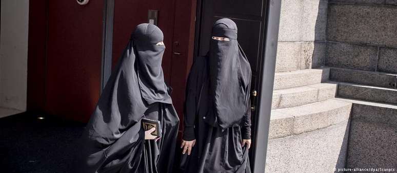 Mulheres vestindo uma burca deixam o Parlamento da Dinamarca, após votação da lei