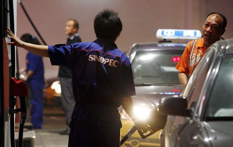 Funcion&aacute;rio abastece carro em posto de gasolina em Pequim, China 05/11/2010 REUTERS/David Gray 