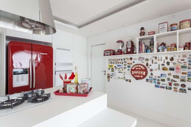 32. Cozinha branca com geladeira colorida vermelha em destaque. Projeto de Mariana Luccisano