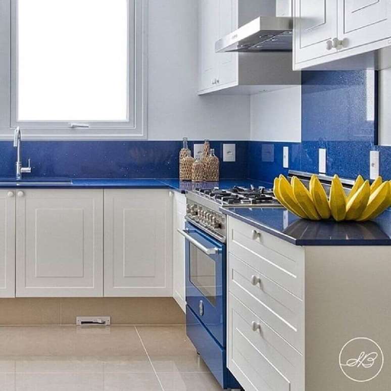 51. Decoração em tons de branco e azul em cozinha compacta com balcão