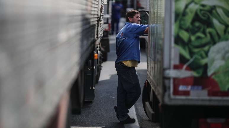 Homem em meio a caminhões parados em greve no Rio de Janeiro; paralisação expôs dependência do país nos combustíveis fósseis