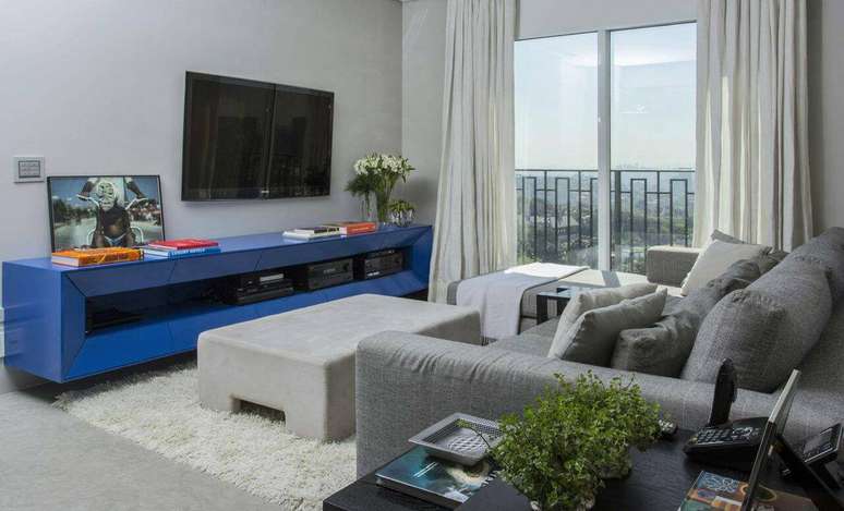 19. A sala de estar com decoração clean dá destaque ao rack na cor azul. Projeto por Triplex Arquitetura