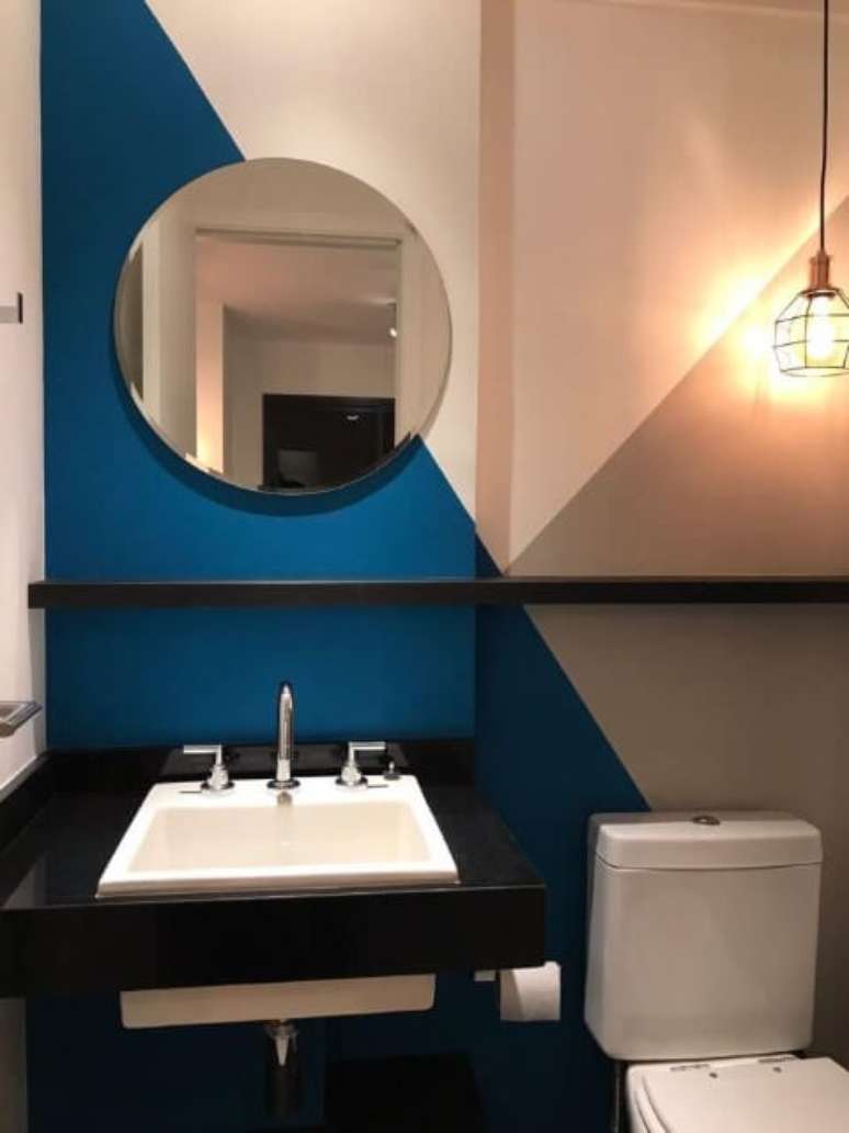 70. Banheiro com parede com três cores e espelho redondo. Projeto de Casa On