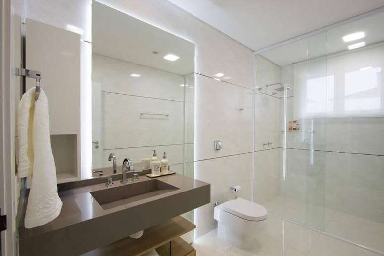 1. O espelho para banheiro com iluminação atrás deixa o ambiente mais bonito. Projeto por Studio Kza