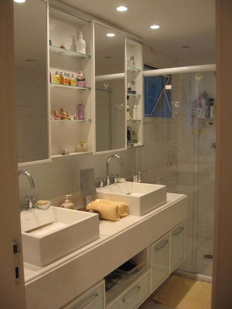 20. Armários para banheiro com espelho e pia dupla, um exemplo de praticidade. Projeto por Escala Design