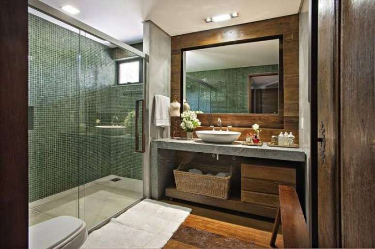27. O espelho para banheiro com revestimento de madeira deixa o ambiente mais aconchegante. Projeto por Gislene Lopes