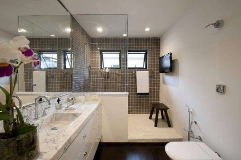 28. O espelho para banheiro pode ocupar a extensão da bancada e chegar até o teto, como no projeto de Beto e Norea