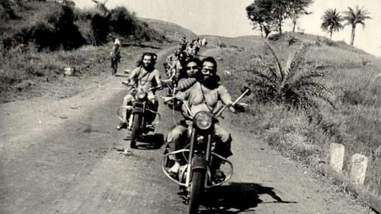 Sheela e outros sannyasins andando de moto na &Iacute;ndia