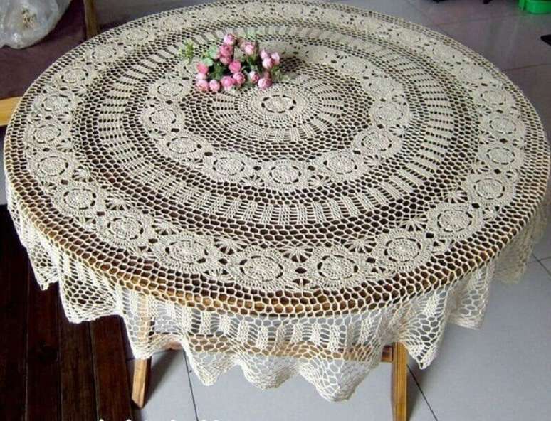 25. Mesa de madeira com toalha de mesa redonda de crochê