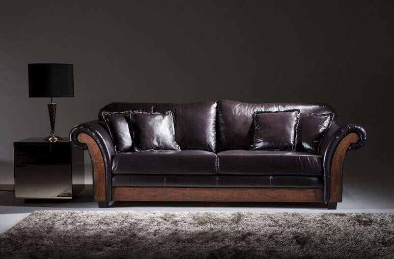 Decoração de sala com tapete cinza e sofá de couro preto com estilo provençal