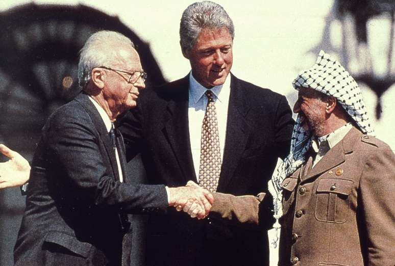 Yitzhak Rabin (esq) e Yasser Arafat se cumprimentam sob o olhar de Bill Clinton; Acordos de Oslo n&atilde;o sa&iacute;ram do papel