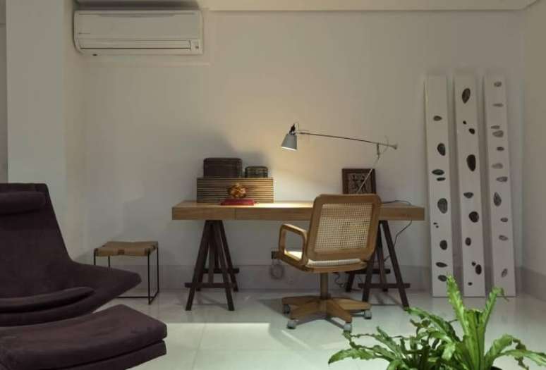 54. Escrivaninha de madeira com cavalete e luminária em cima. Projeto e Renata Basques