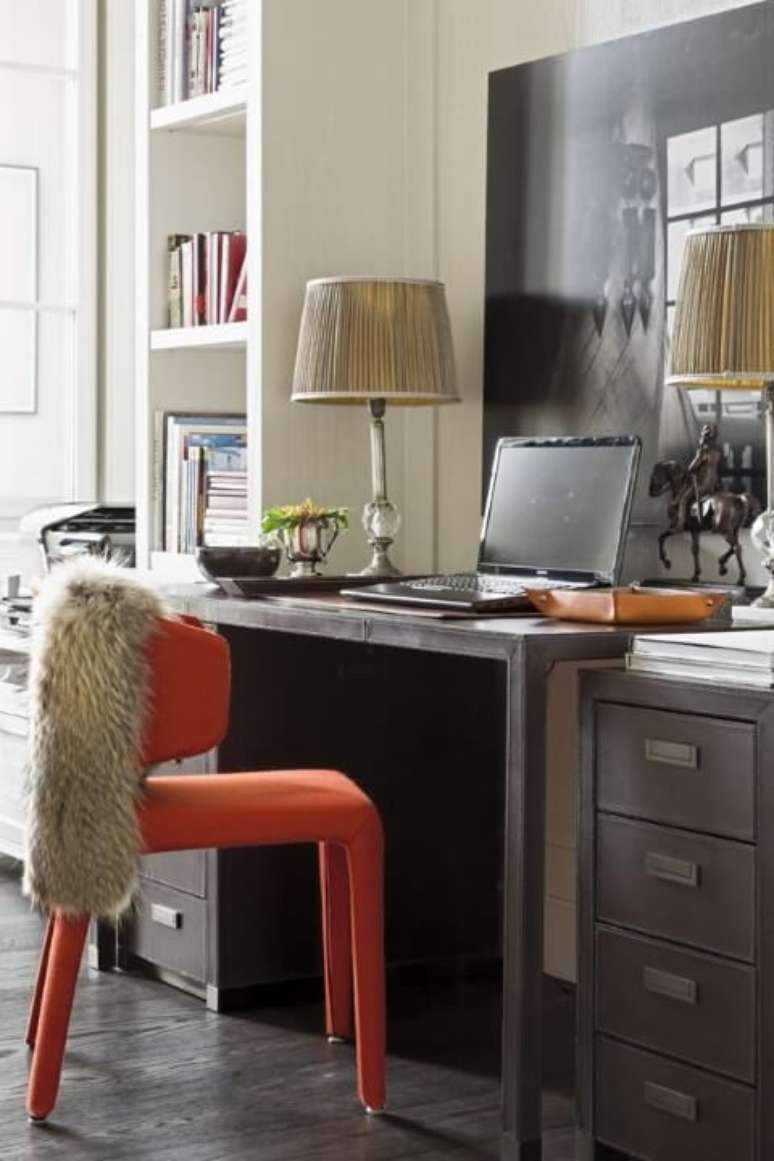 50. Escrivaninha de madeira escura com cadeira laranja. Projeto de Roberto Migotto