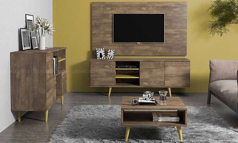 2. Sala de TV com painel de TV e demais móveis de madeira com pés palito, um detalhe clássico do estilo retrô. Projeto de Lojas KD