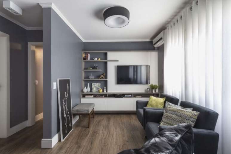 31. Sala com paredes cinzas e m&oacute;veis escuros. Projeto de Modi Arquitetura