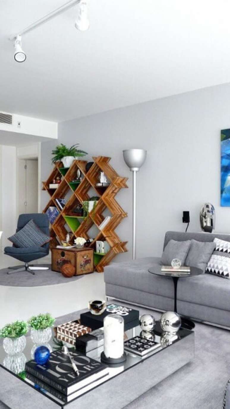 57. Os tons de cinza contrastam com a estante de madeira, mas ficou bem interessante. Projeto de Rafael Samman