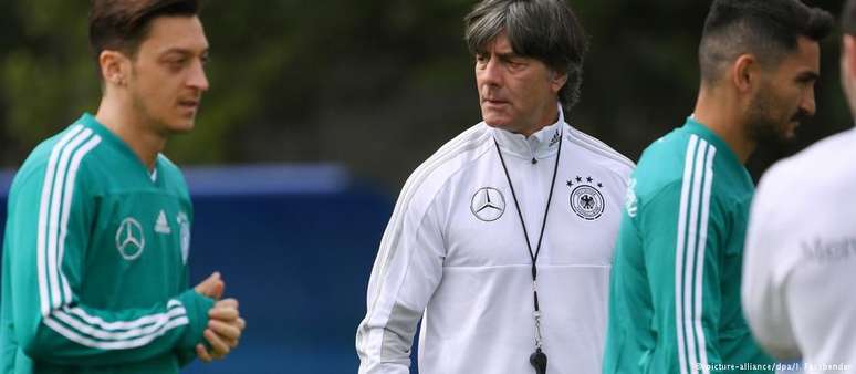 Joachim Löw, ao fundo, comanda treino com Özil (esq.) e Gündogan (dir.) já na Rússia