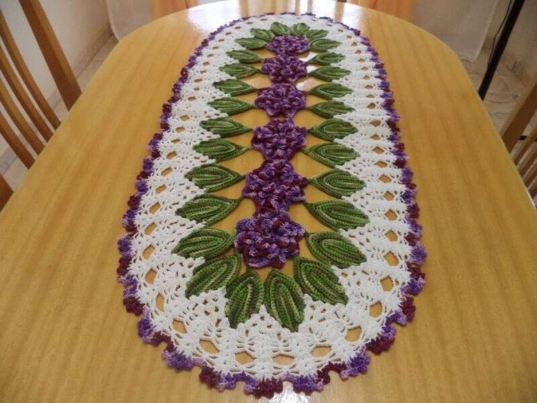 29. O caminho de mesa tamb&eacute;m pode receber flores e folhas em croch&ecirc; para deix&aacute;-lo mais bonito