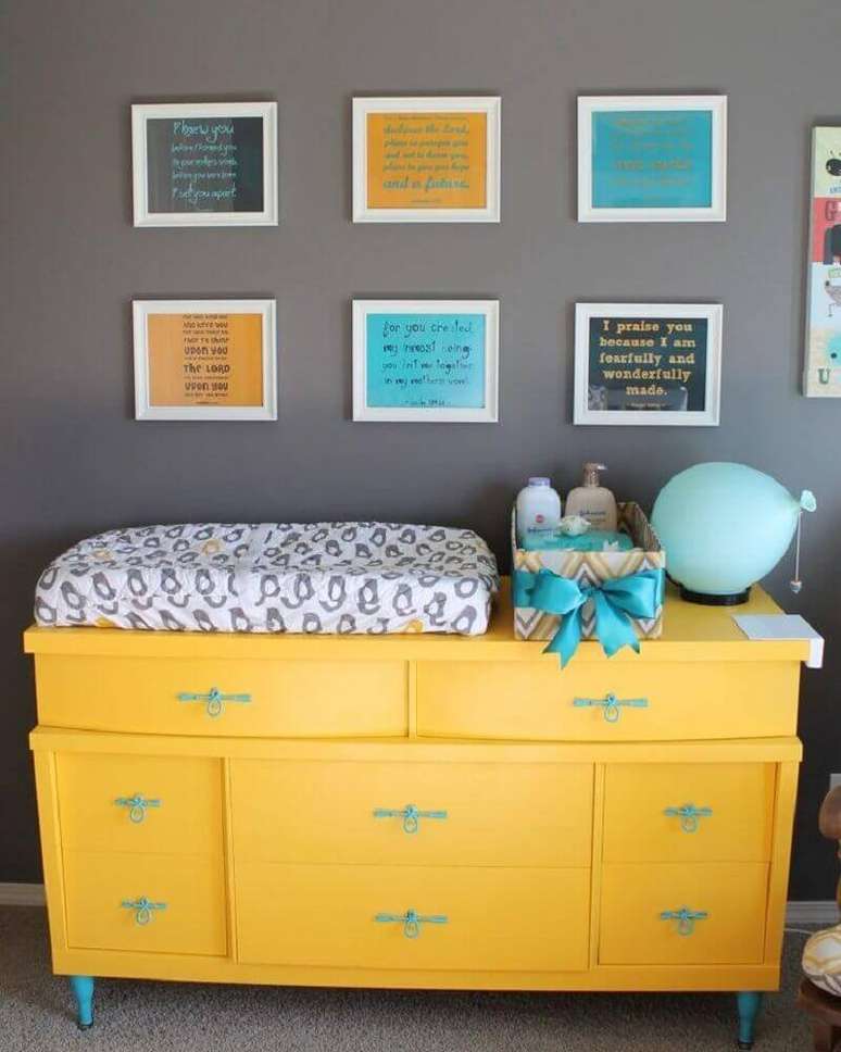 21. A cômoda com trocador amarela e puxadores azuis além de ser um móvel muito útil para os pais, também trazem mais cor e beleza ao quarto