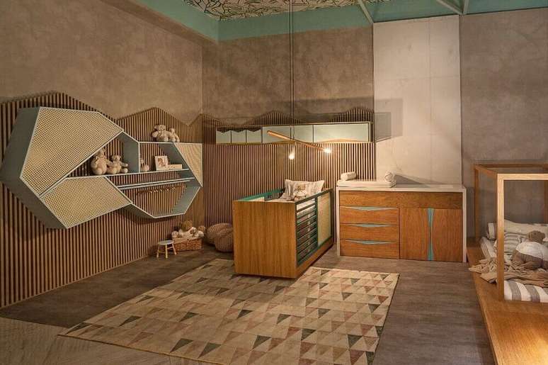 8. Decoração moderna para quarto de bebê com nichos assimétricos e berço e cômoda para quarto de bebê feitos de madeira com detalhes azuis.