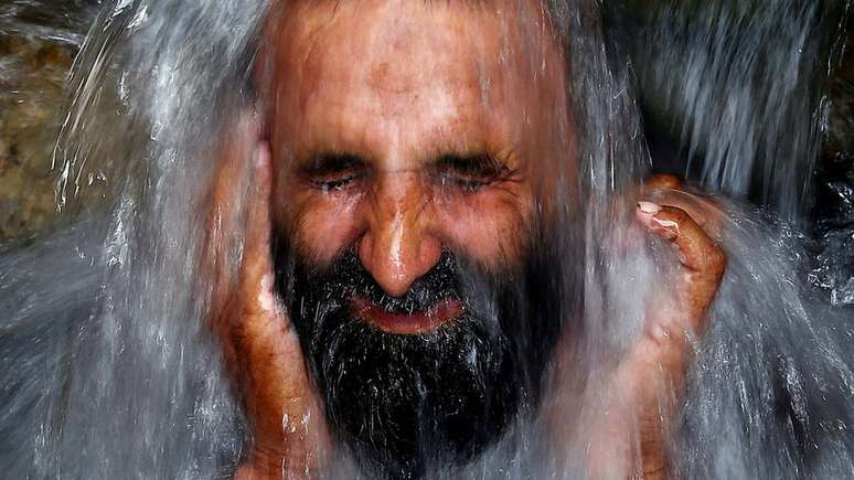 Homem se refresca durante a onda de calor em Karachi, no Paquistão, quando pelo menos 60 pessoas morreram