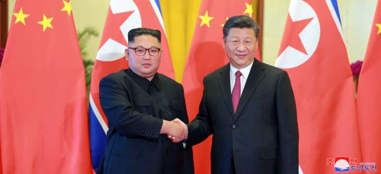 L&iacute;der da Coreia do Norte, Kim Jong Un, e presidente da China, Xi Jinping, em Pequim, em foto divulgada em 20 de junho pela KCNA KCNA via REUTERS