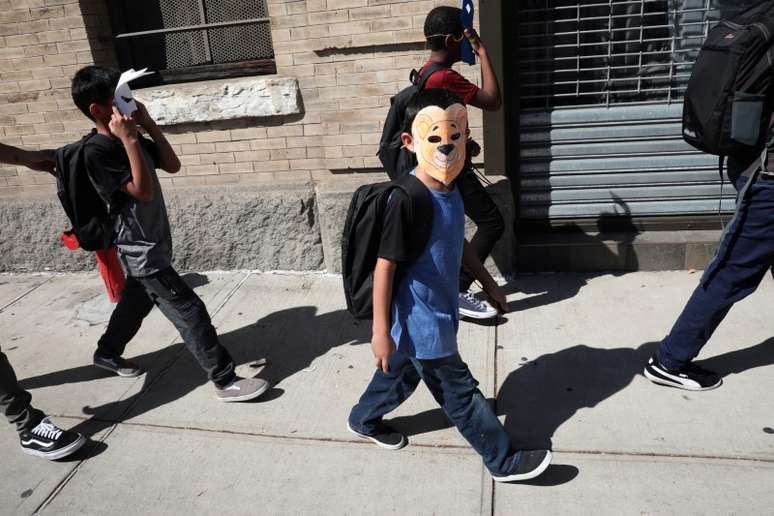 Crianças, com máscaras, deixam Centro Cayuga, que ofere serviços a crianças imigrantes separadas das famílias, em Nova York 21/6/2018 REUTERS/Mike Segar 