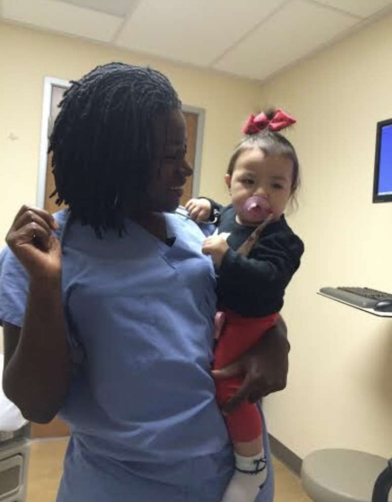 Sarpoma com uma das beb&ecirc;s que ajudou a trazer ao mundo durante a resid&ecirc;ncia em Cuba