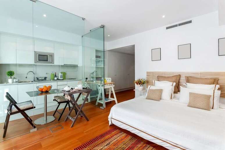 O apartamento pequeno com paredes de vidro fica visualmente maior e integra os ambientes