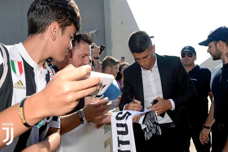 João Cancelo dá autógrafos a torcedores da Juventus na sua chegada ao centro médico da equipe.