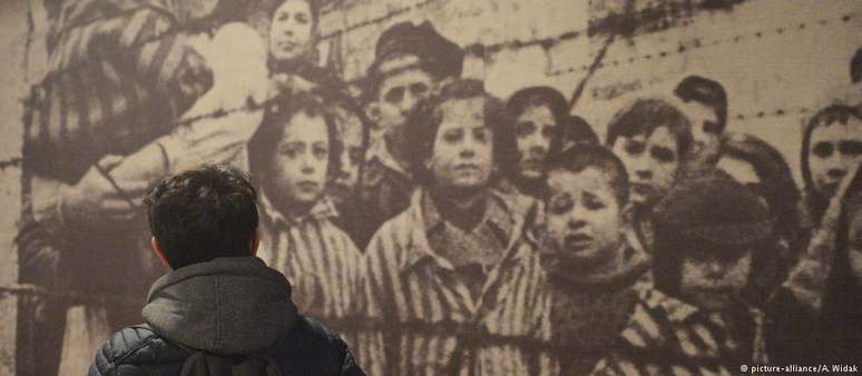 Visitante observa painel da exposição permanente no campo de concentração de Auschwitz, na Polônia