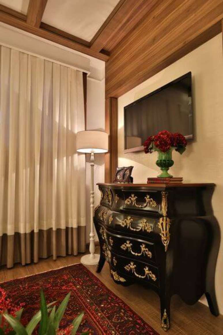 22. Uma c&ocirc;moda retr&ocirc; preta com detalhes dourados tem um visual bem forte e cl&aacute;ssico. Projeto de Majo Arquitetura