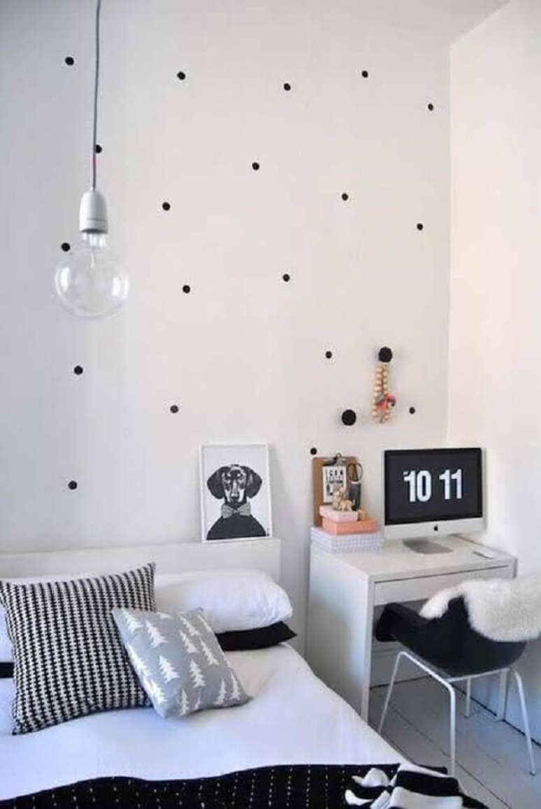 7. Decoração de quarto preto e branco com papel de parede de bolinhas e escrivaninha pequena e simples ao lado da cama