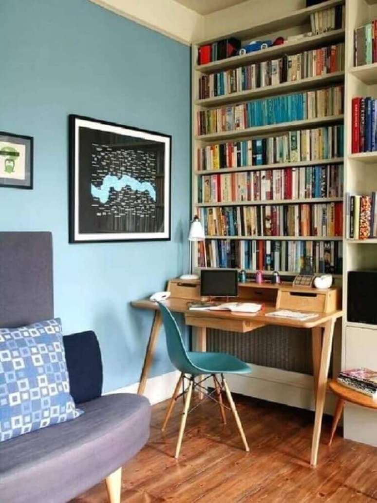 21. Sala de estar decorada com escrivaninha simples de madeira estante de livros