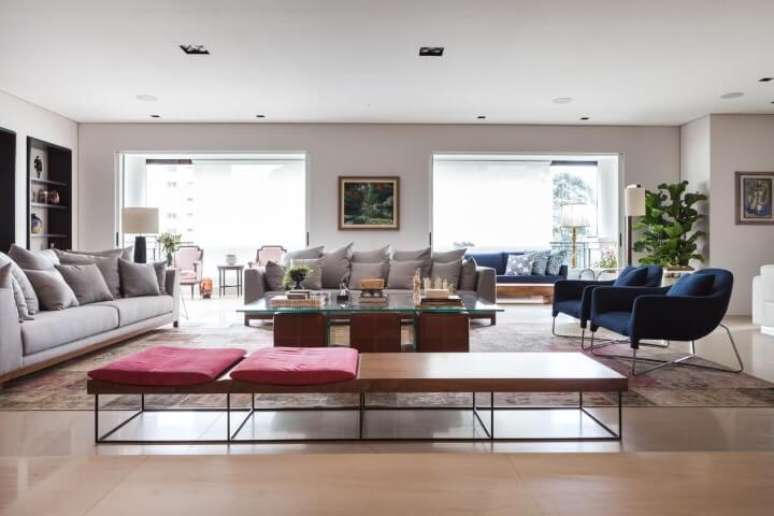 21. Sala de estar com recamier de madeira longo e almofadas vermelhas. Projeto de Oleg&aacute;rio de S&aacute;