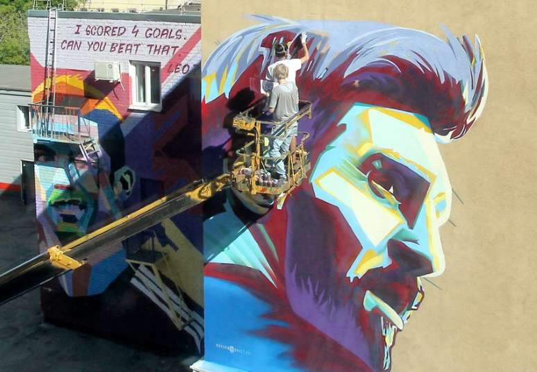 Artistas russos pintam mural de Messi perto a mural de Cristiano Ronaldo 29/06/2018 REUTERS/Alexey Nasyrov