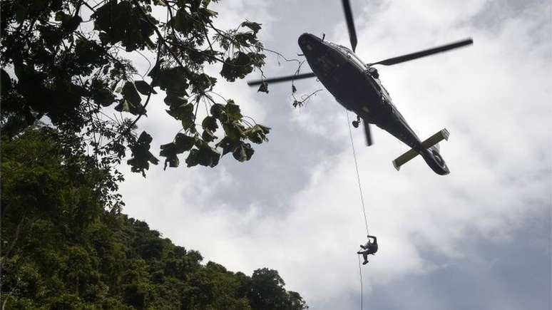Pelo ar, em helicópteros, equipes de resgate buscam passagens para dentro da montanha