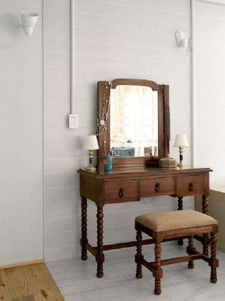 36. A penteadeira com espelho feita de madeira é garantia de um toque rústico e confortável à decoração