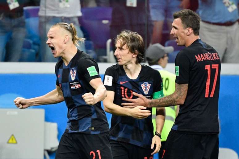 Modric, entre o zagueiro Vida e o atacante Manduzic, vibra muito. Afinal, após jogo dramático com a Dinamarca, só decidido nos pênaltis, a Croácia avança para as quartas de final da Copa e vai encarar a Rússia (AFP)
