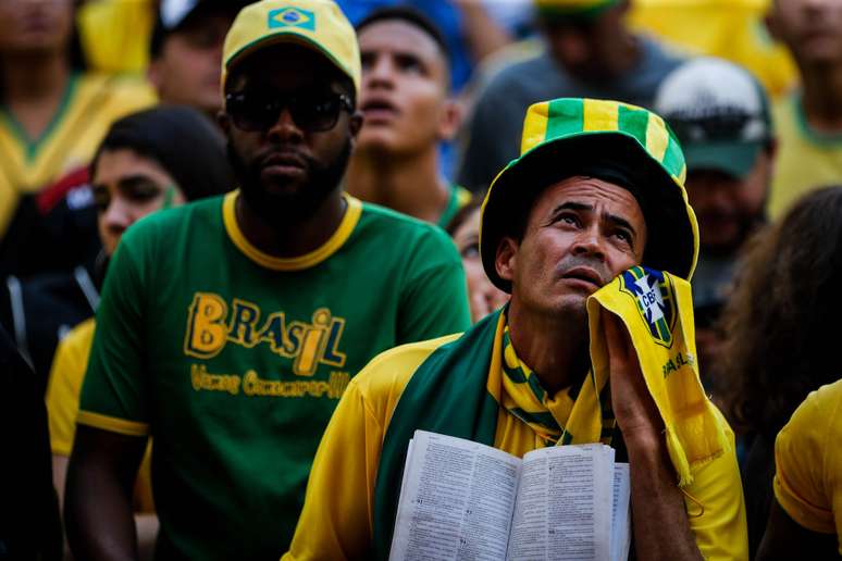 Torcedor brasileiro segura a B&iacute;blia, enquanto assiste ao jogo do Brasil contra o M&eacute;xico na Arena N1