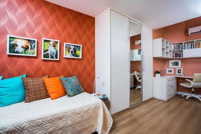 18. Quarto de solteiro decorado com paredes vermelhas e guarda roupa solteiro branco com portas de correr